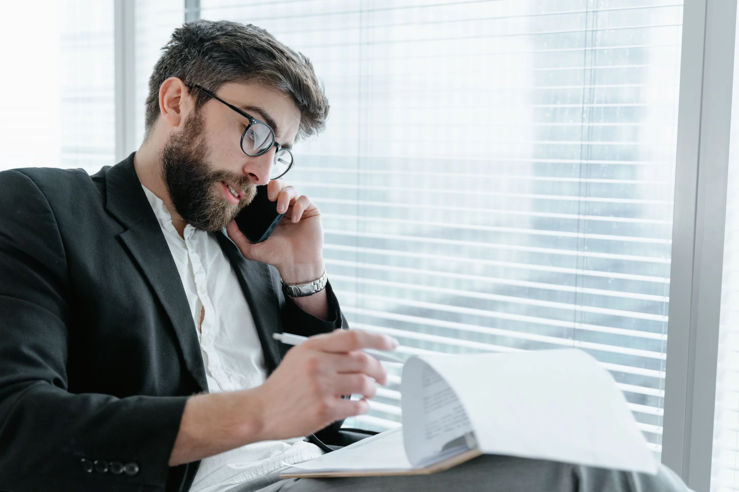 Commercial au téléphone qui annote un devis entre deux rendez-vous